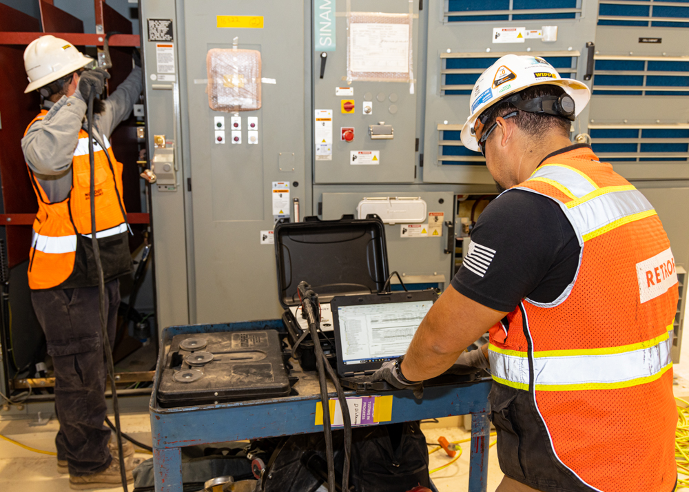Workers testing electrical circuits